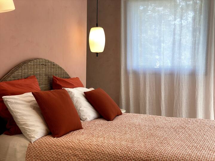 Dormitorio 1 coral en el lado sur con su baño con ducha. 2 grandes bahías dan acceso directo a la piscina y al Pool House Vista piscina y jardín.