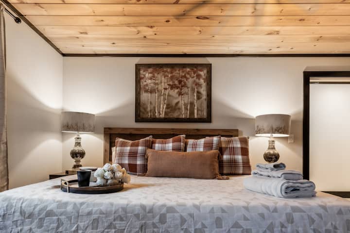 Bedroom Retreat: Unwind in style with plush decor, warm lighting, and scenic woodland art!