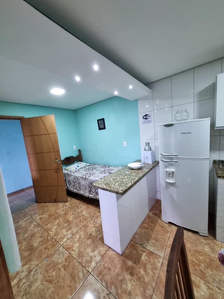 Პატარა საძინებელი ამერიკული სტილის ერთადგილიანი საწოლით სამზარეულოს გვერდით.