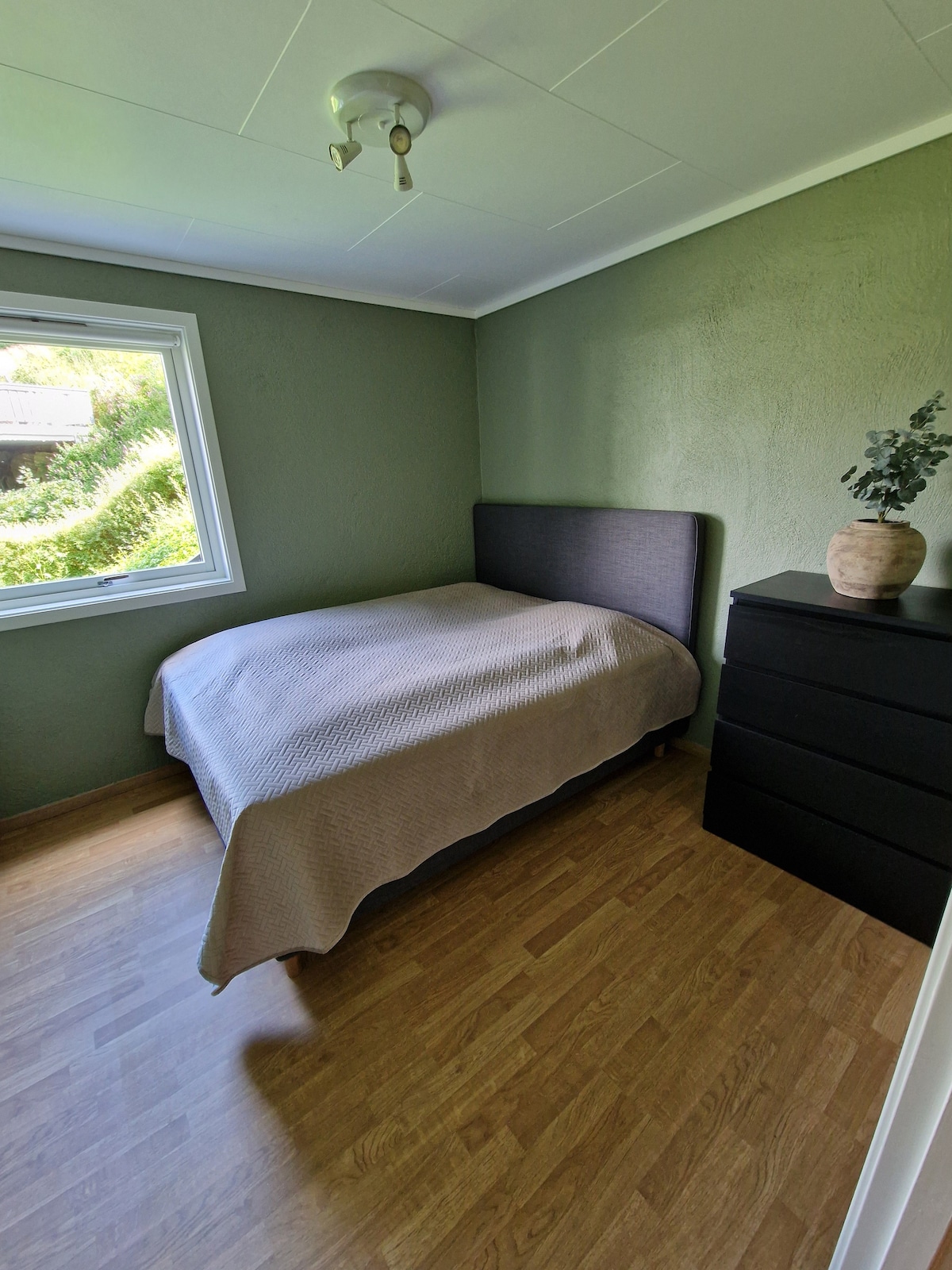 Habitación cálida en el primer piso con cama doble (150x200).  Almacenamiento de ropa en la cómoda y el gancho. 