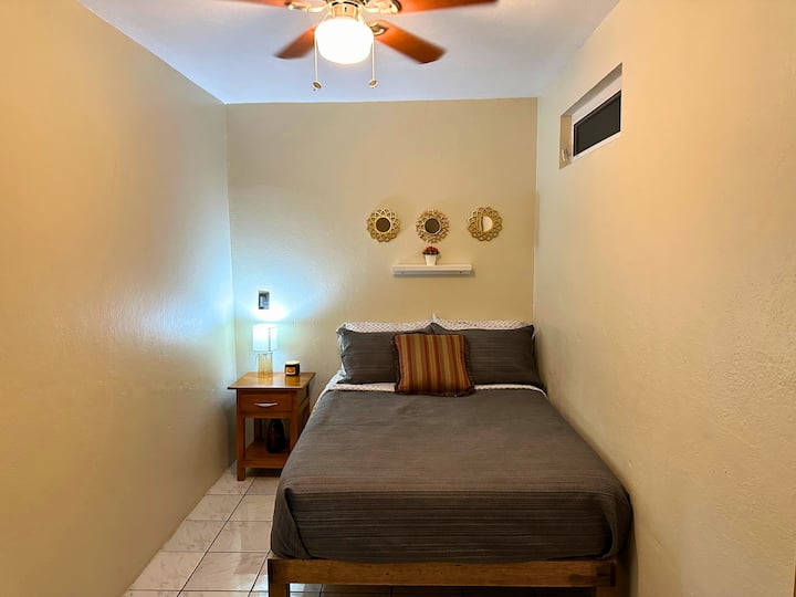 Este acogedor dormitorio privado en la segunda planta tiene ropa de cama cómoda y un ventilador de techo para que puedas dormir tranquilamente.