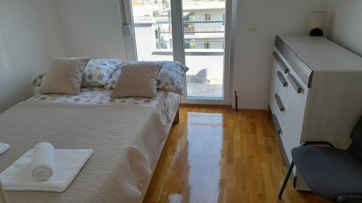 Cozy beige-toned bedroom with a comfortable double bed.