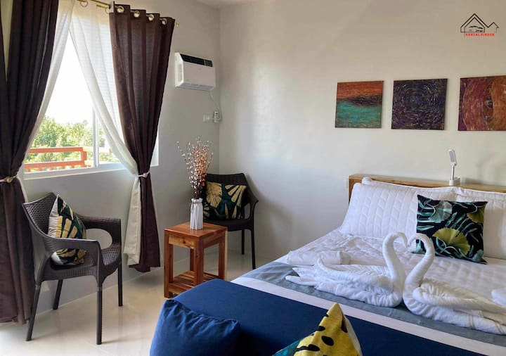 Rilassati in questa accogliente camera da letto con un letto comodo, cuscini soffici e biancheria morbida. Goditi un ambiente elegante e terroso con opere d'arte murali uniche, un'illuminazione calda e tende per un sonno ristoratore perfetto, ideale per il massimo relax e comfort.