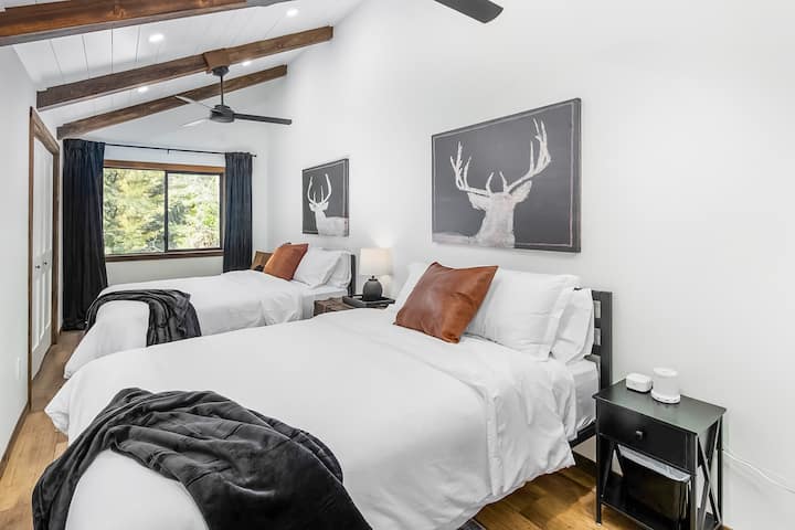 Third bedroom features 2 queen beds adorned with deluxe white linens, additional pillows and cozy blankets.  Lamps come equipped with USB charging ports and sound machines for a restful night.