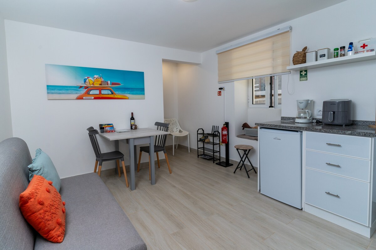 Cocina en espacio abierto, integrada en la sala de estar, con una pequeña mesa de comedor, creando un entorno acogedor y funcional, perfecto para momentos familiares.