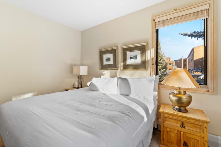 Spálňa pre hostí na hlavnej úrovni s manželskou posteľou veľkosti King a televízorom. 