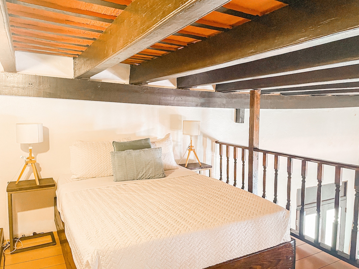 Cama queen estilo loft abierto.