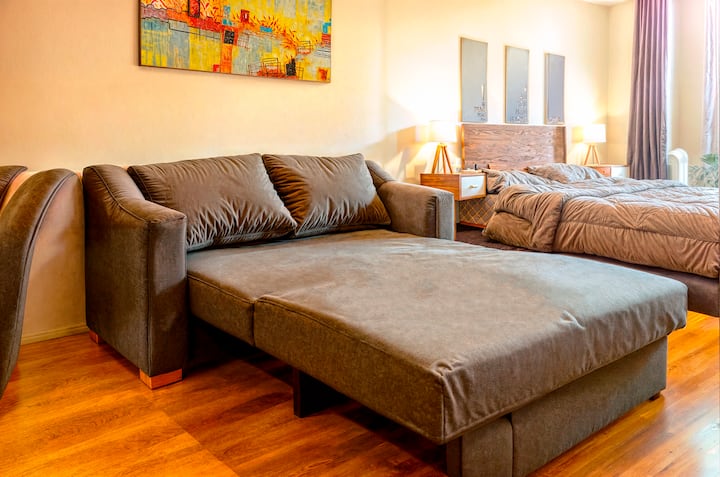 מגורים מרווחים ומוארים עם ספה נפתחת נוחה, אידיאלית למנוחה או כמיטה נוספת. עיצוב מודרני חמים שיוצר מקום מושלם למנוחה או לרגעים ייחודיים במהלך השהייה.