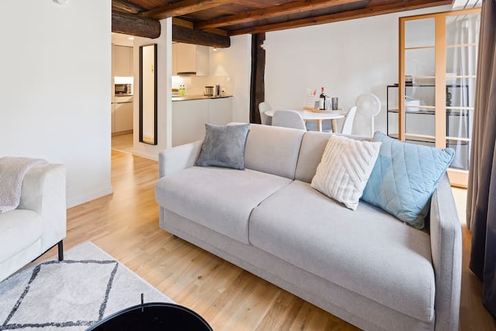 Ugodan dnevni boravak otvorenog plana s modernom kuhinjom i blagovaonicom.








