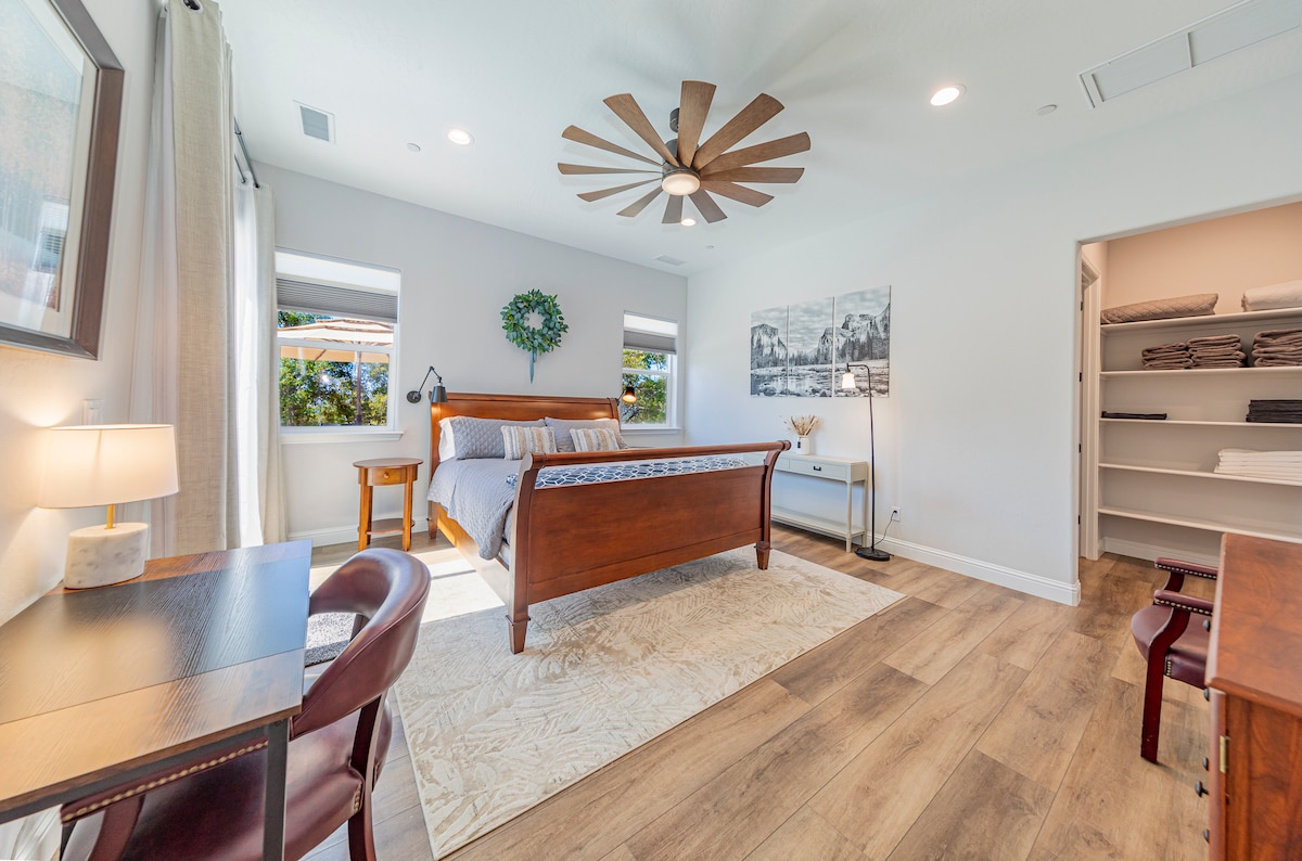 מיטת קינג סייז, שולחן כתיבה וטלוויזיה חכמה גדולה.