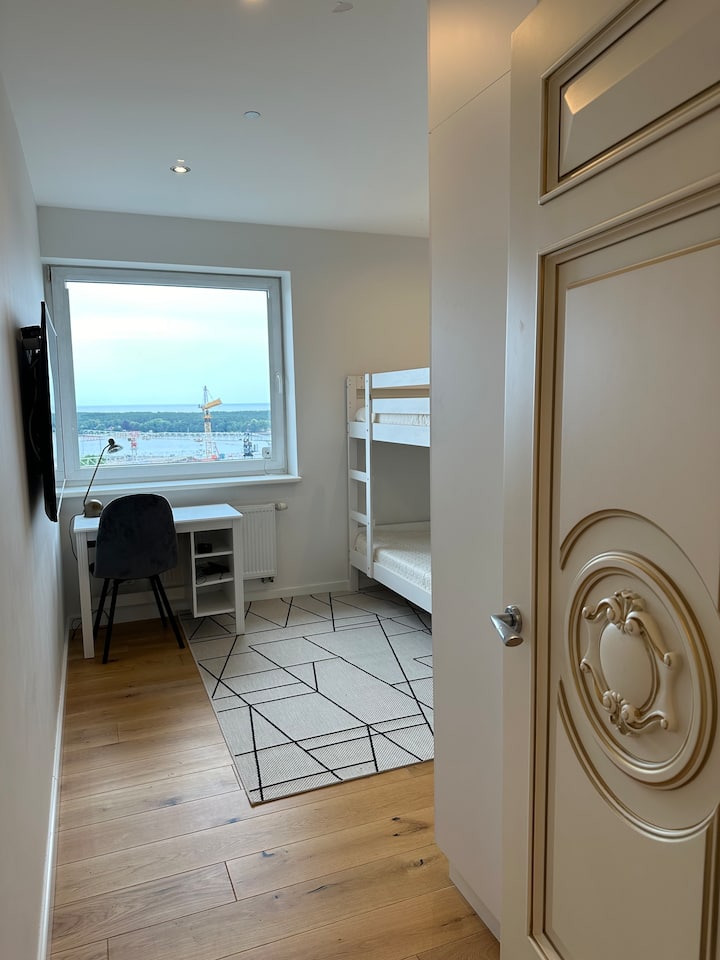 Acogedor dormitorio de 12 m² con vista al mar, TV y armario grande, seguridad en la ventana. Cuenta con una litera Ikea (90x200 cm) para 2 niños o adultos jóvenes (máximo 70 kg cada uno). Incluye también una cuna portátil para bebés.