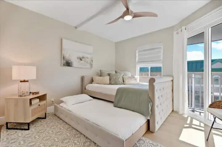 Cama tamaño queen con cama nido individual, SmartTV, ventilador de techo y acceso al balcón.