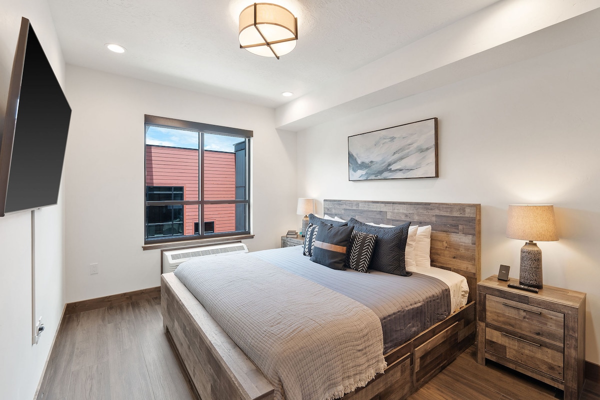 Დიდი საწოლი 55"-იანი სამსუნგის ტელევიზორით, უსადენო ტელეფონის დამტენები თითოეულ ტუმბოზე, საწოლის ქვეშ და კარადა სათავსოებით და ოთახის კონდიციონერით/გამათბობლით.