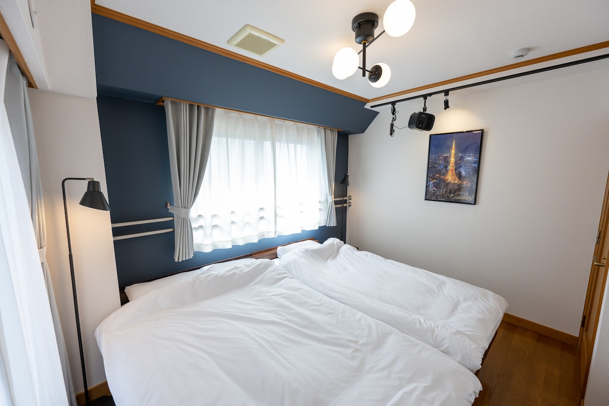 Уютна спалня с единично легло и полудвойно легло. Дълбоката синя акцентна стена добавя стилен щрих, а обилната естествена светлина и удобните легла осигуряват спокоен престой. Идеално за семейства или групи, които търсят релаксиращо място за отдих.