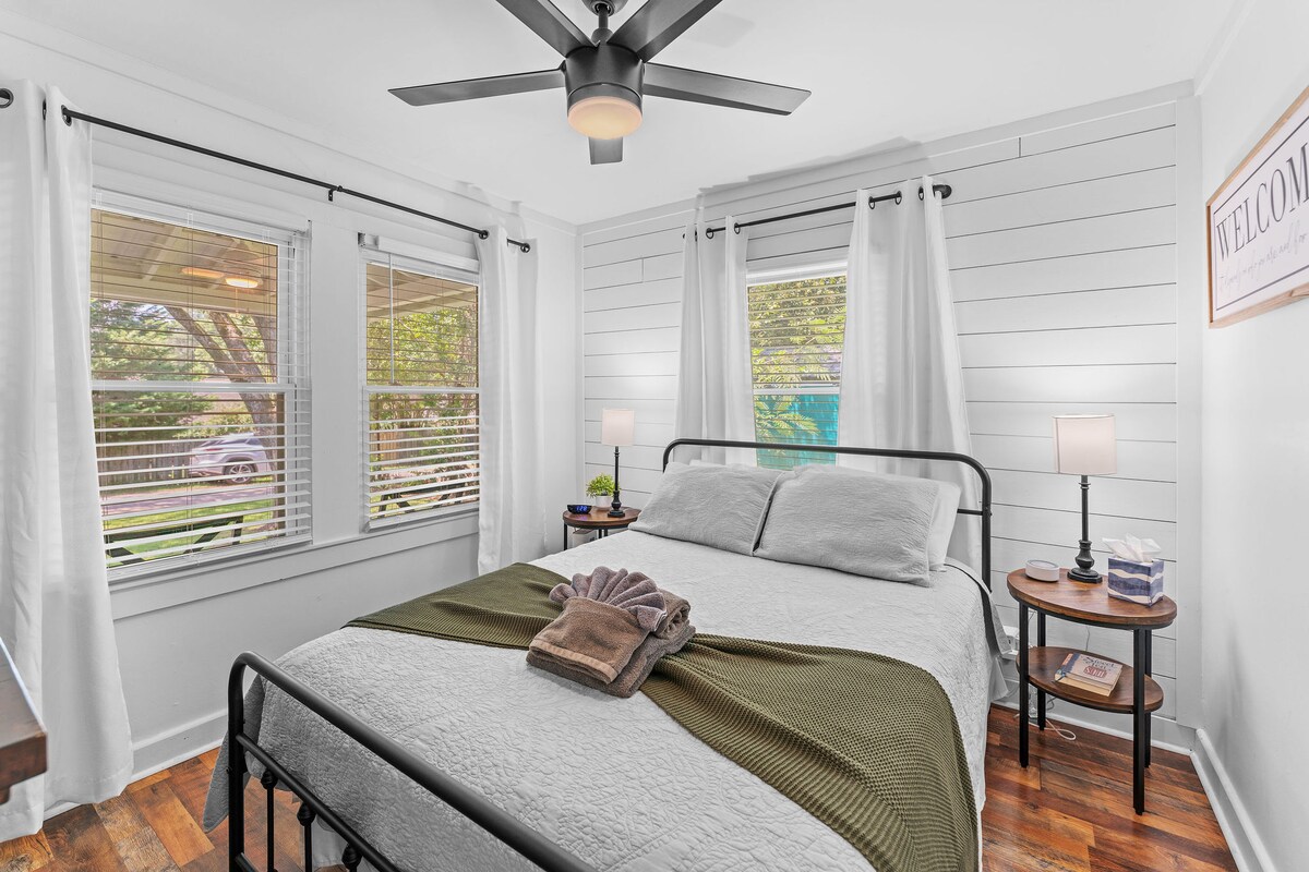 غرفة النوم رقم 1 (غرفة النوم الرئيسية) مع سرير بحجم كوين ومروحة سقف وإضاءة طبيعية ساطعة من نوافذ متعددة