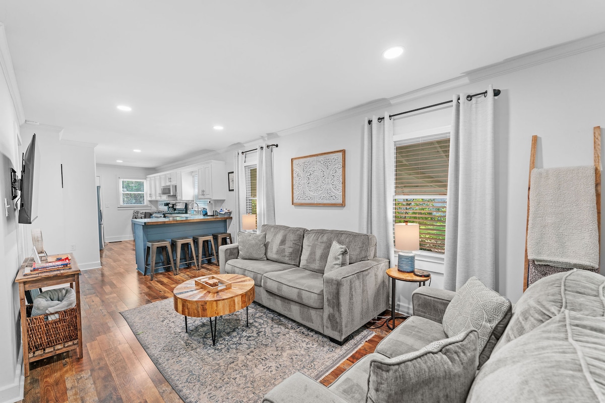 غرفة معيشة مفتوحة مع إطلالة واضحة على المطبخ ومنطقة تناول الطعام