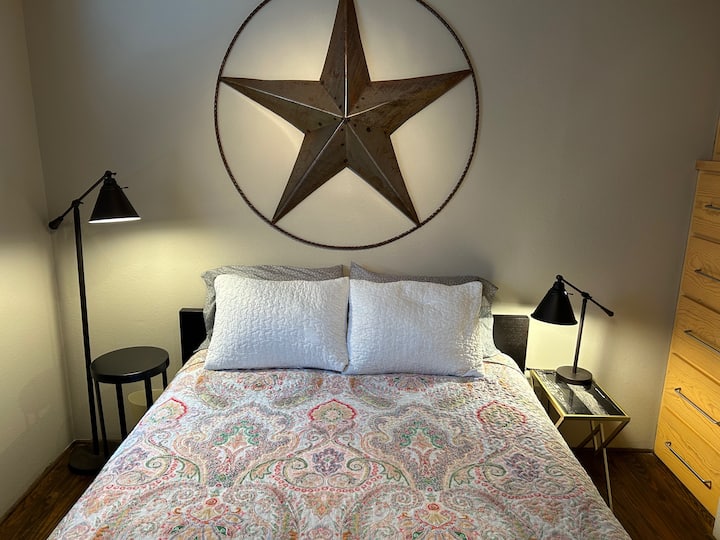 חדר שינה שני עם מיטת קווין סייז ושפע של מקום אחסון.