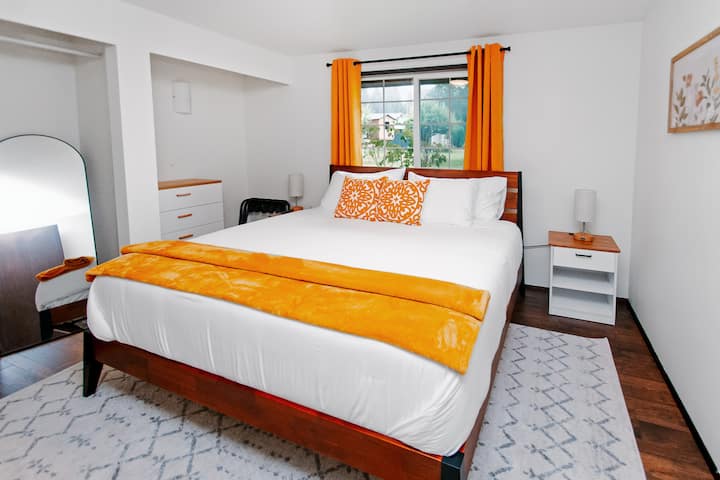 King bedroom downstairs with cotton linens, 50" Smart TV (Roku Guest Mode) and nightstands with USB charging.