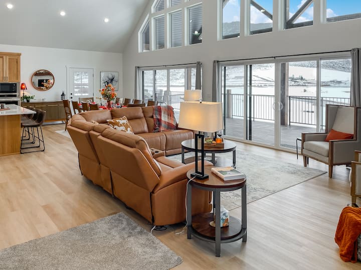 Veľké okná zapĺňajú obývací priestor prirodzeným svetlom a výhľadom na rieku.