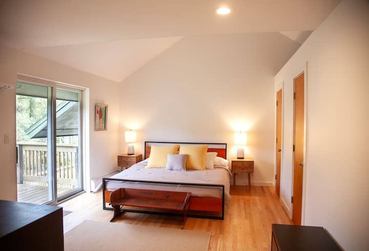 غرفة نوم رئيسية بسرير كبير وخزانة ملابس وصناديق من الأدراج وشرفة جولييت خاصة مع إطلالات على البركة والجبل.