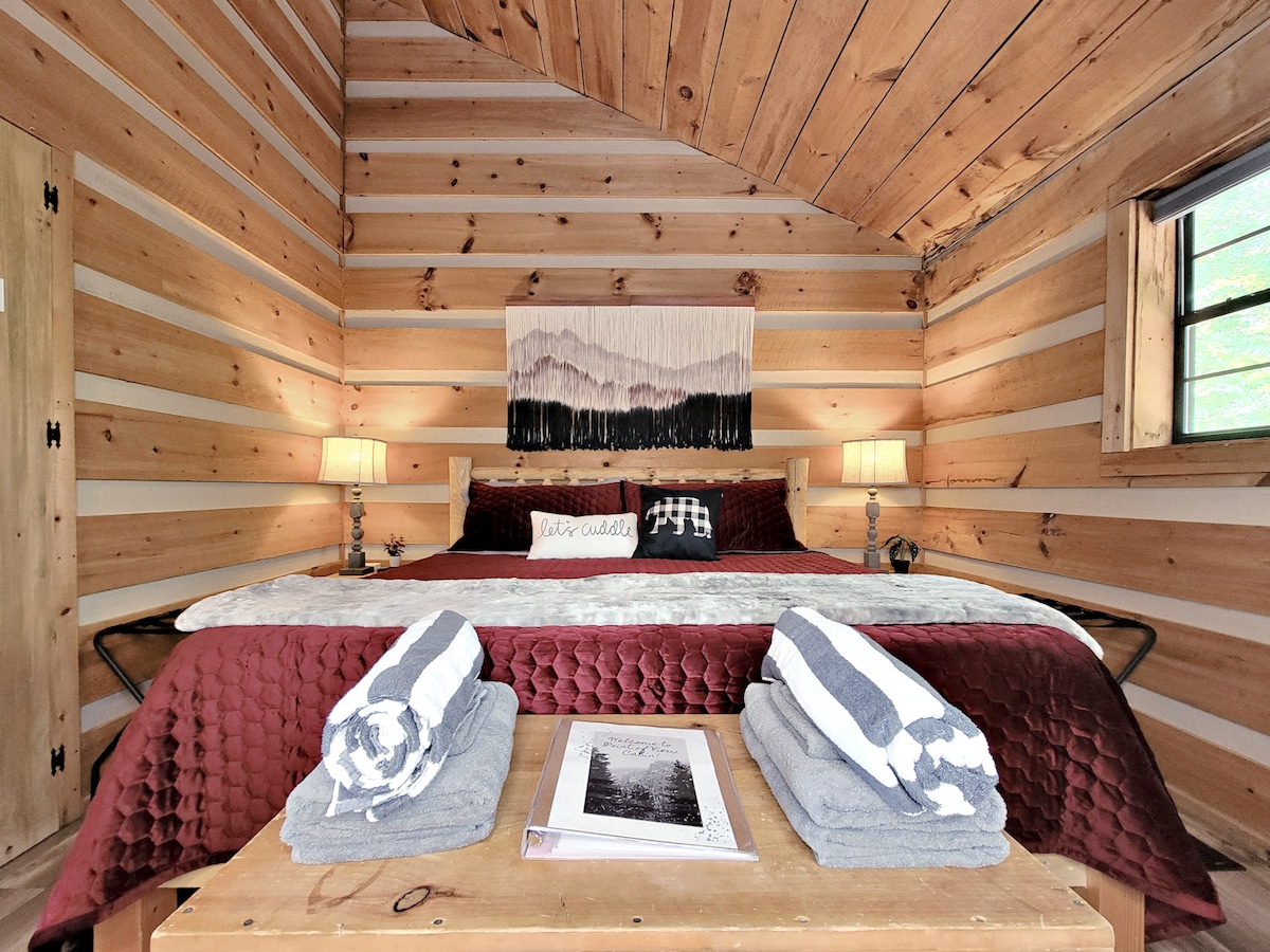 Cozy up in the king-size bed at Point of View Cabin, surrounded by rustic charm and peaceful forest views. Sweet dreams await! ✨