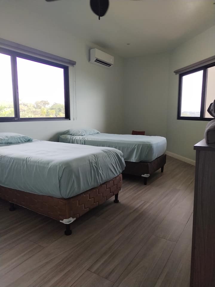 Gemütliches Schlafzimmer mit Meer- und Bergblick. Es gibt eine Klimaanlage für Komfort und dunkle Jalousien für einen erholsamen Schlaf oder Privatsphäre. Ideal zum Entspannen und gleichzeitig eine atemberaubende Landschaft zu genießen.