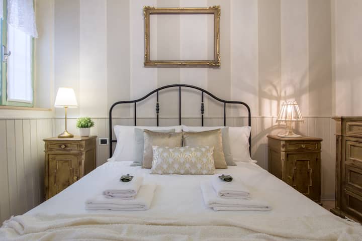 camera da letto matrimoniale, soffitto a cassettoni, completa di letto matrimoniale in stile moderno, materasso con topper, due comodini in stile antico, lampada da comodino per entrambi gli ospiti, cassettiera con specchiera in stile antico