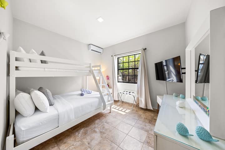 セカンドベッドルーム| Villa Leoneの2つ目の寝室には、シングルオーバークイーンとテレビを備えた快適な二段ベッドが備わっており、すべてのゲストに快適でリラックスした滞在を保証します。