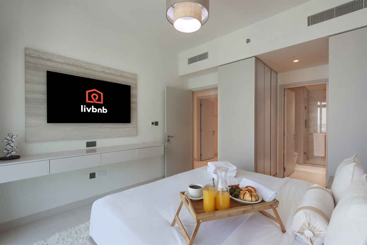 חדר שינה מעודן עם מיטת קינג סייז וטלוויזיה חכמה משולבת
