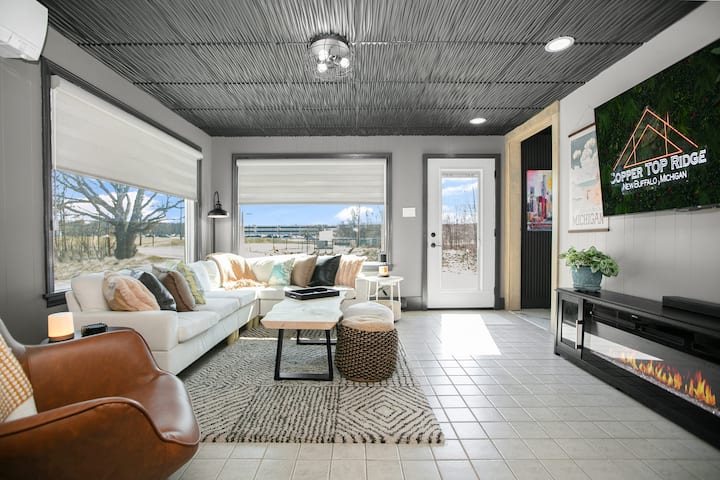 Novouređeni dnevni boravak osmišljen za udobnost i opuštanje. Uživajte u toplom sjaju kamina i svojim omiljenim emisijama na televizoru od 65 inča. Motorizirane sjenila za zamračivanje prostorija pružaju savršen ambijent. Samo nekoliko koraka od kasina Four Winds!