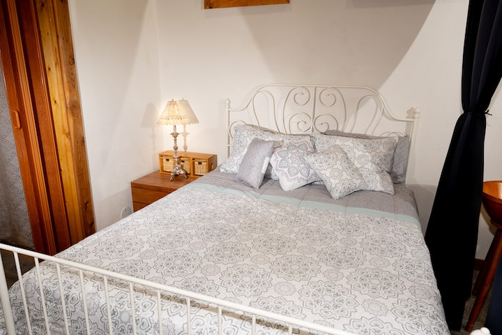Rest easy in the comfortable downstairs queen bed, conveniently located right next to the bathroom for easy access at the Forest Cabin near Silverwood Theme Park.