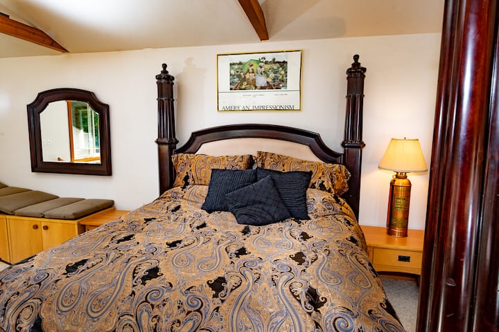 Retreat to the master suite featuring a four-pillar king bed and decor at the Forest Cabin near Silverwood Theme Park.