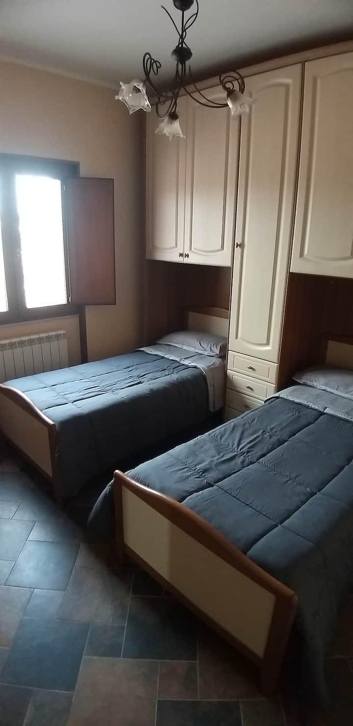 غرفة مزدوجة مع سريرين مفردين تقع على الأرض مجهزة بسخان وتكييف هواء وخزانة ملابس كبيرة وكومو