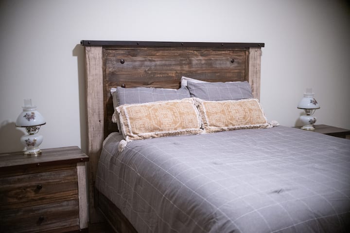 Bedroom two includes a full-size bed, dresser, nightstands, lamp lighting, chair for seating, and closet.