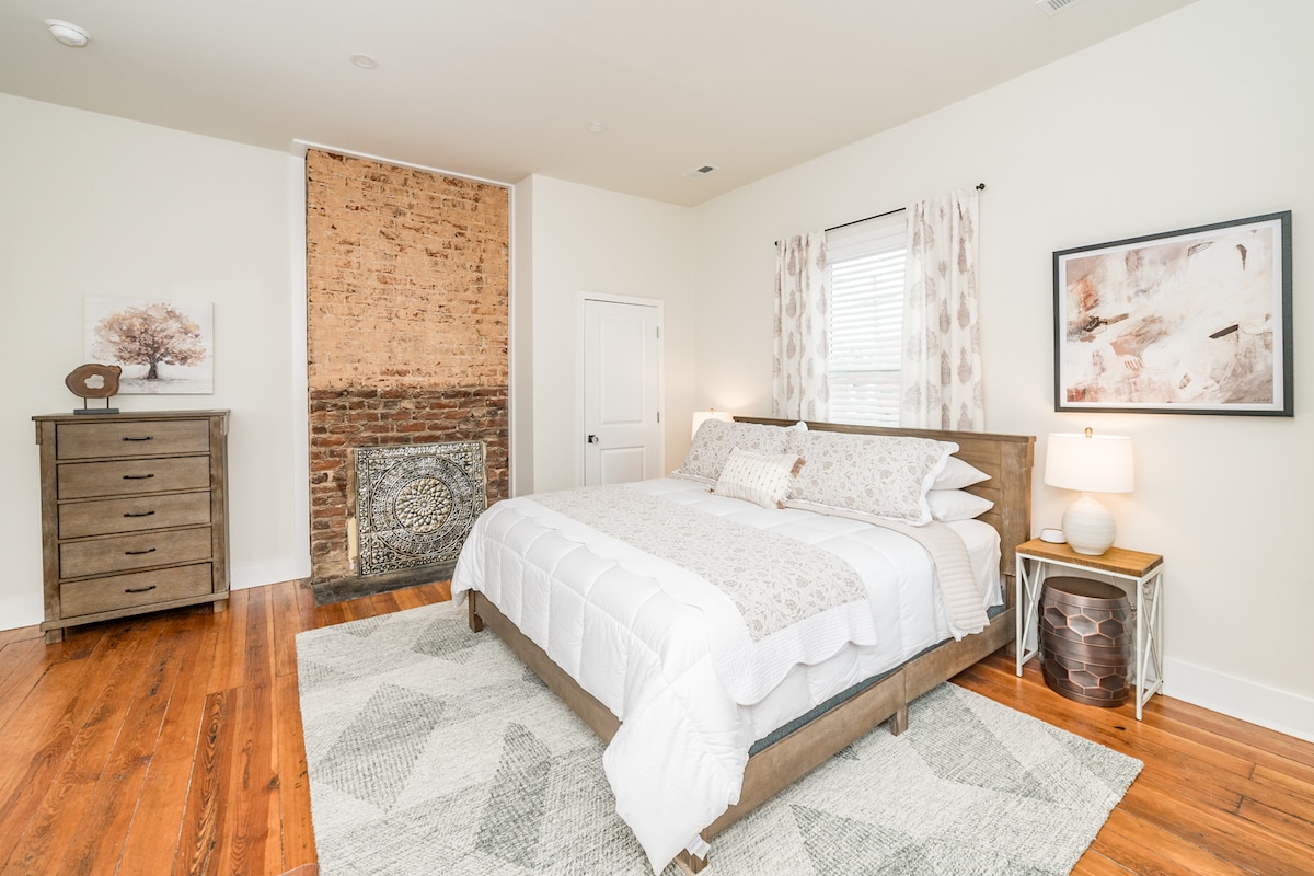 Upstairs bedroom with king bed, TV, dresser, desk, and closet.