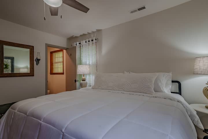 primary bedroom features on suite bathroom with shower, windows giving plenty of natural light to enjoy the green space outdoors