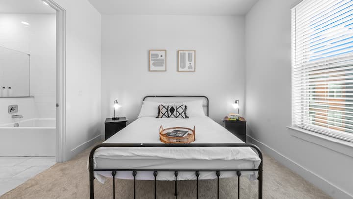 El dormitorio ofrece un refugio de lujo, con una cama que promete noches de descanso y una habitación que se siente como un oasis privado.