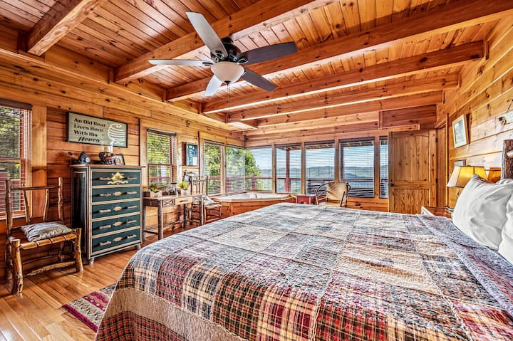 חדר השינה כולל גם שידה לאחסון נוסף. אפשר לראות נופים מרהיבים של הרים דרך החלונות הגדולים המשקיפים על הדק האחורי.