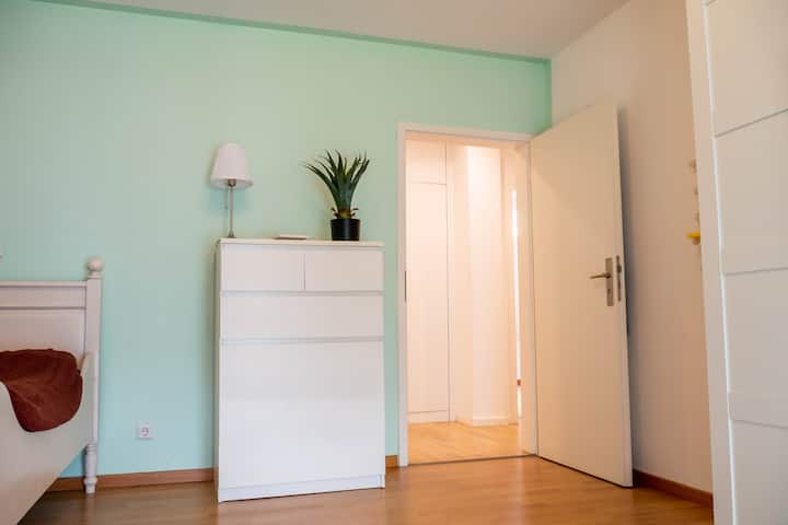 Spavaća soba s balkonom, jednostrukim krevetom, radnim stolom i ormarom 