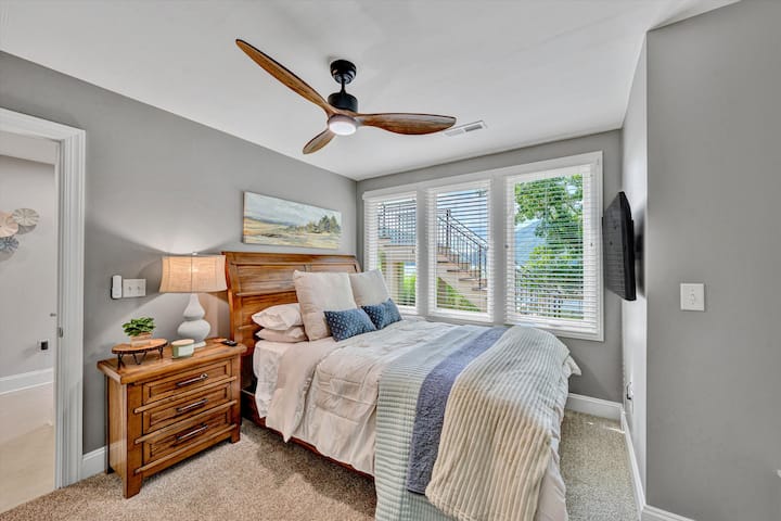 חדר שינה תחתון עם מיטת קווין סייז. הכי קרוב לדלת האחורית שמובילה לג'קוזי ולמדרגות האחוריות לרציף. נעים ונוח עם נוף יפהפה לאגם ולהר! טלוויזיה חכמה, מאוורר תקרה ותריסים לפרטיות. מנעולי דלתות לפרטיות.  