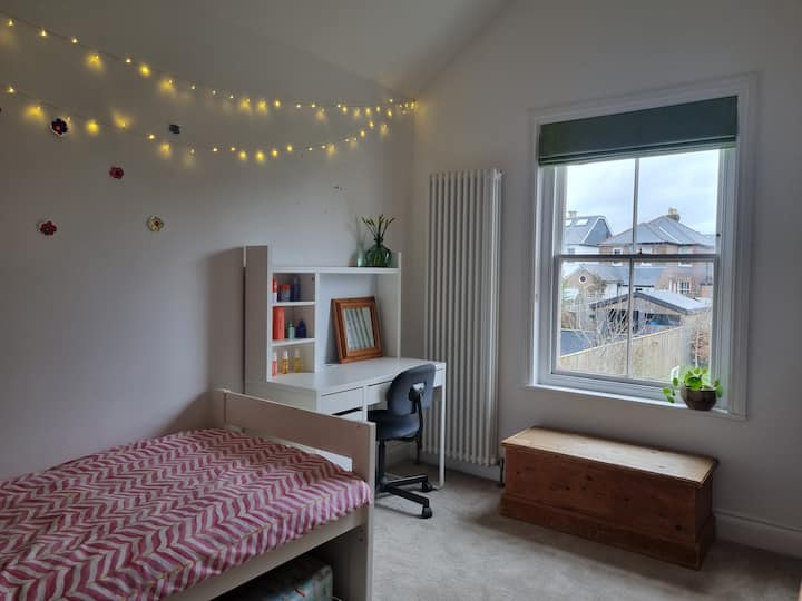 חדר שינה יחיד עם תקרה מקומרת מרשימה, המשקיף החוצה אל הגינה האחורית. 