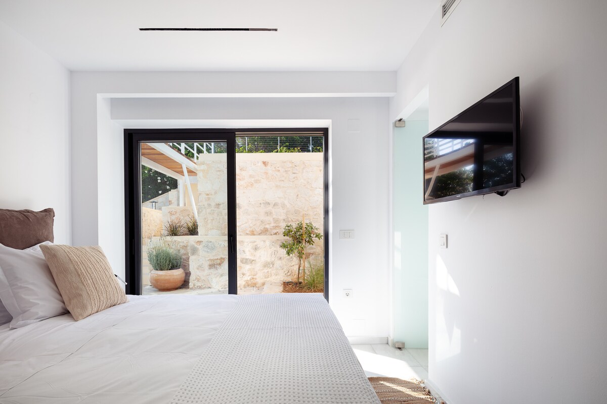 This bedroom features a king-size bed an en suite bathroom with a shower, a spacious floor-to-ceiling closet, a 32” TV, and direct outdoor access.