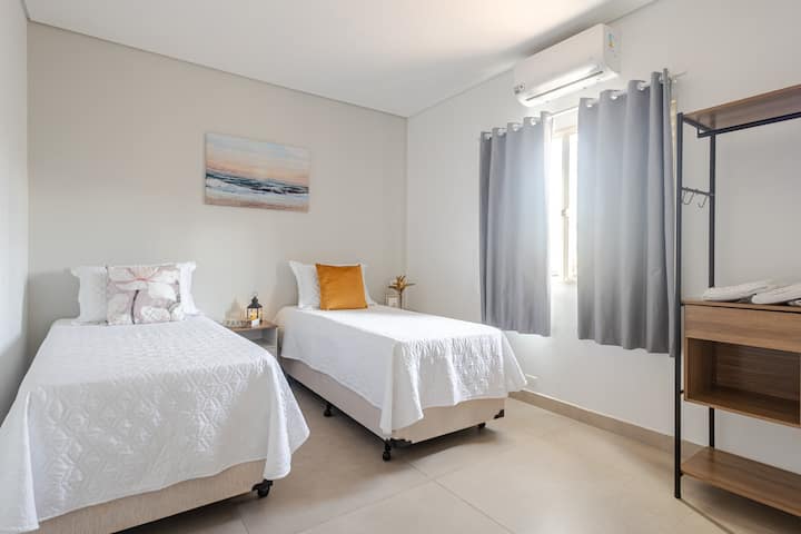 Apartman 1 s dva jednostruka kreveta s zavjesama za zamračivanje, klima-uređajem, TV-om, bočnim stolićem, ormarom, posteljinom i ručnicima. 