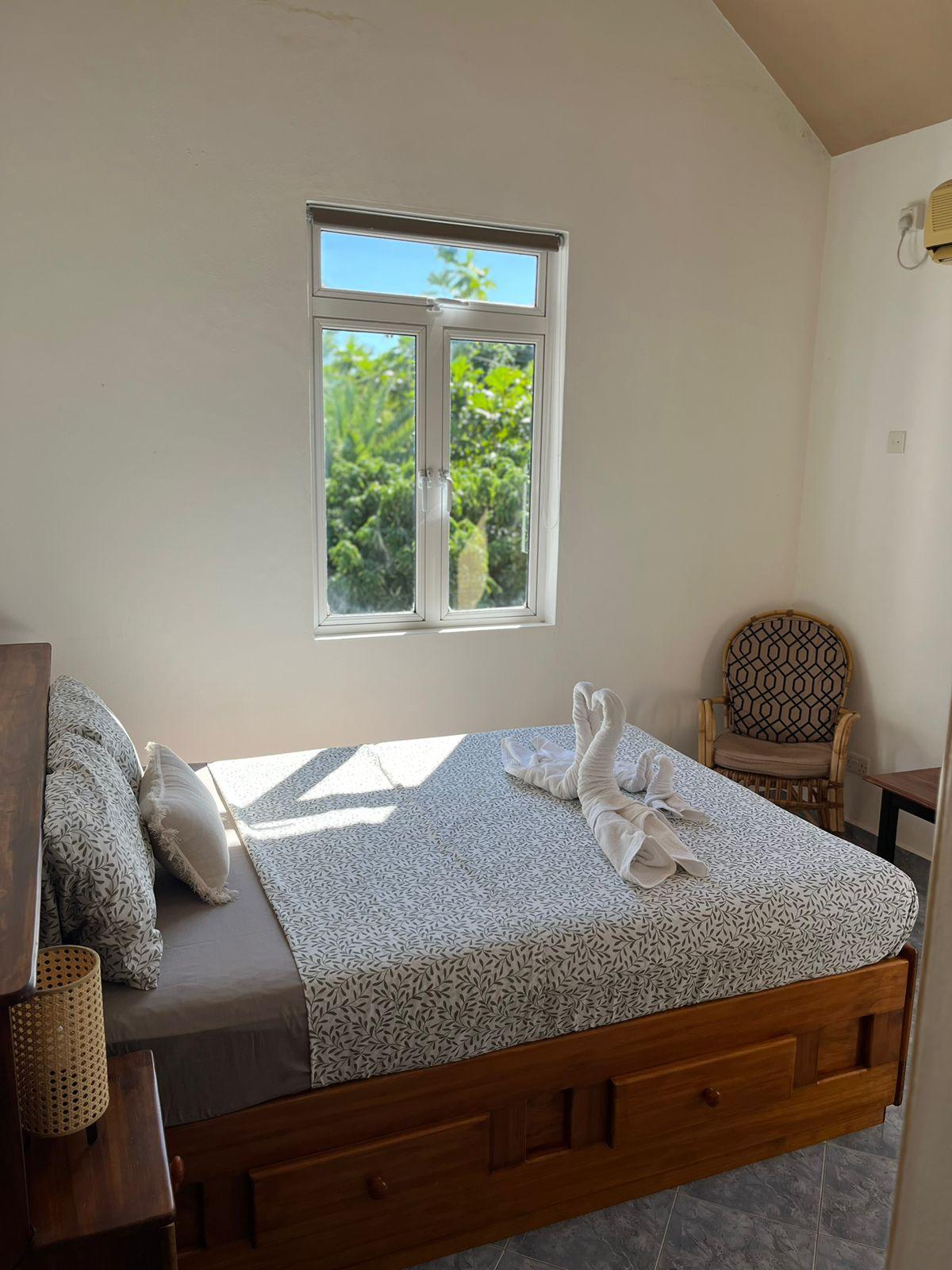 卧室面积约10平方米，配备2张床头柜和1盏床头灯。 床前有一张小桌子和扶手椅。 