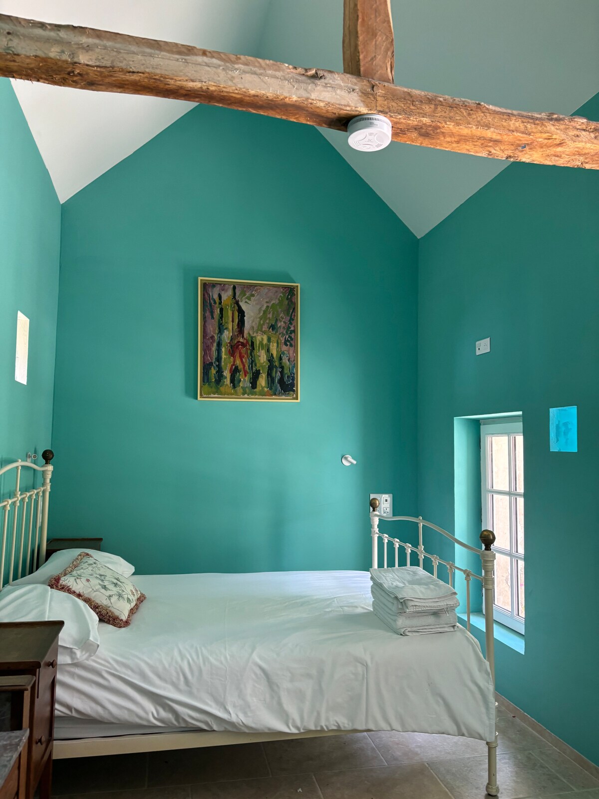 Fusion d'ancienne et de neuve, cette chambre à haut plafond est aérée et lumineuse, et donne sur sa propre terrasse avec un accès de plain-pied.  Une machine à café et une cruche de filtre à eau vous retiennent rechargés, et un petit-déjeuner fraîchement préparé vous attend le matin (en supplément)