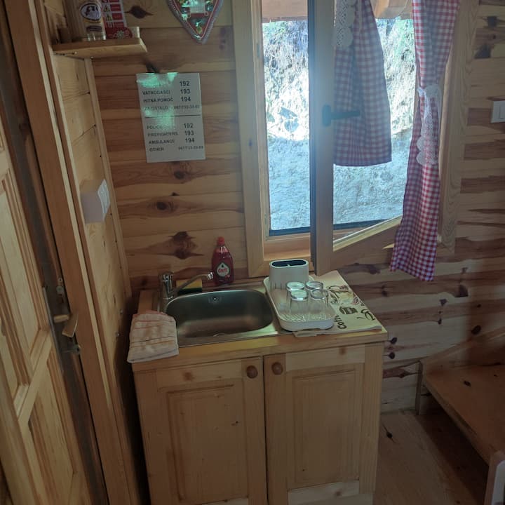 Sudopera sa posuđem i svim priborom za pripremu i konzumiranje hrane u letnjoj kuhinji pored stana.