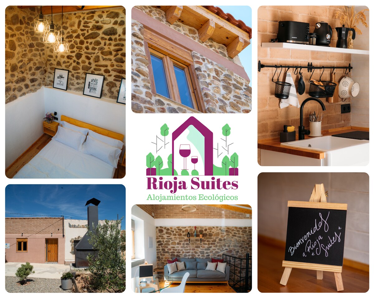 The rustic interior features a spacious sleeping area with a wooden bed frame and art prints on stone walls. A well-equipped kitchen is visible, showcasing hanging cookware and utensils. The outdoor area includes a traditional barbecue, completed with a charming chimney.