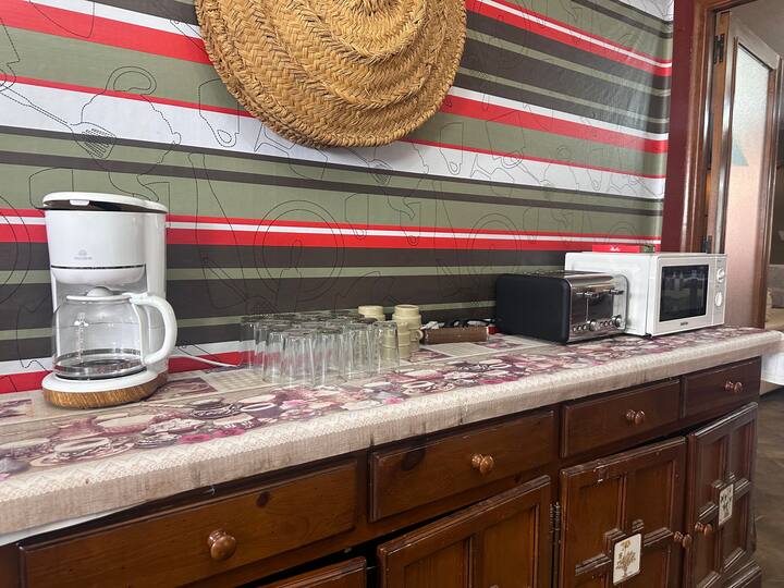 Encimera con cafetera, tostadora y microondas: todo a mano para el desayuno.