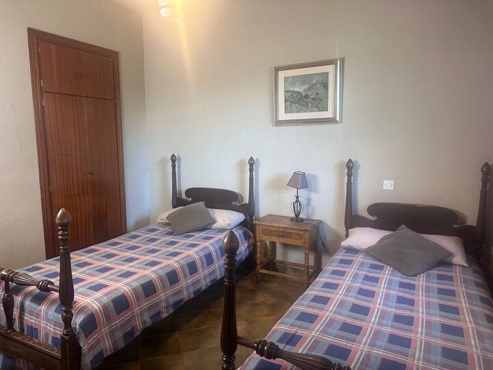Dormitorio 3 con dos camas individuales y cabeceros de madera: acogedor y luminoso.