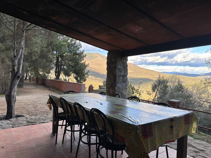 Mesa exterior bajo el porche con vistas a la sierra: comidas con paisaje.
